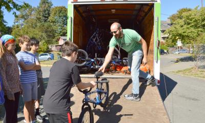 A Cascade Bicycle Club volunteer unloading a U-Haul with bikes to teach youth how to ride